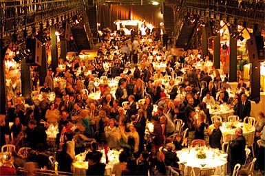 A crowded auction venue filled with gala guests and dining tables: the kind of night that good auction management software makes much easier.