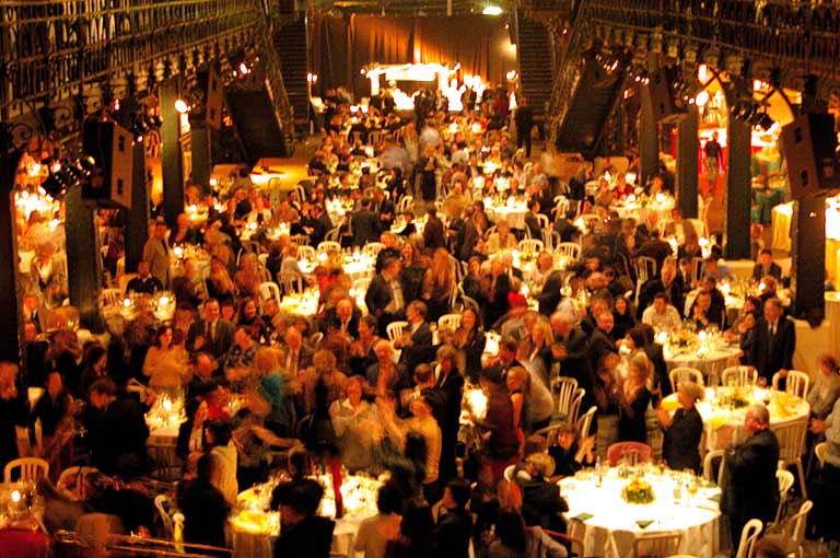 A crowded auction venue filled with gala guests and dining tables: the kind of night that good auction management software makes much easier.